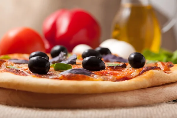 Pizza margherita con tomates, aceitunas y albahaca sobre óxido vintage —  Fotos de Stock