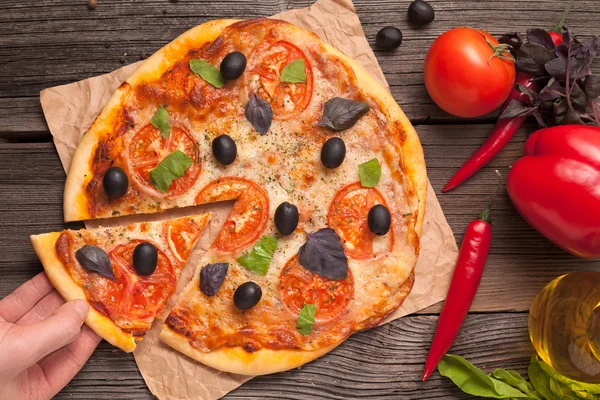 Irreconocible mano de hombre tomando trozos de pizza italiana en rodajas mar — Foto de Stock