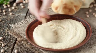 Tanınmayan adam geleneksel Arap çanak Humus, dökme kırmızı biber ve zeytin yağı ile serpilir hizmet vermektedir.