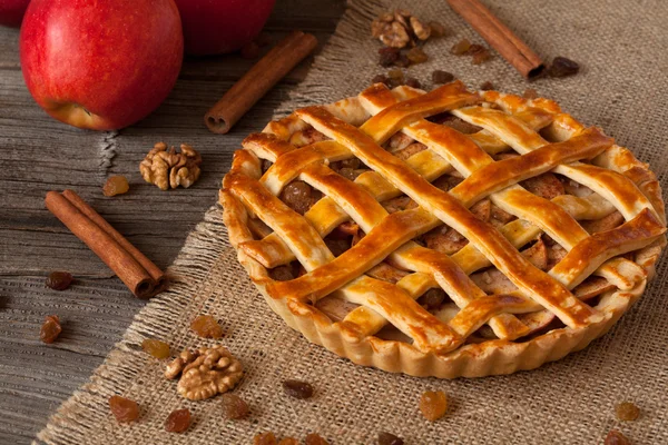 Apple pie with cinnamon on retro wooden background — Stock Photo, Image