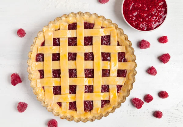 Preparación de pastel de frambuesa americano rústico con mermelada y frambuesas en mesa de cocina blanca — Foto de Stock