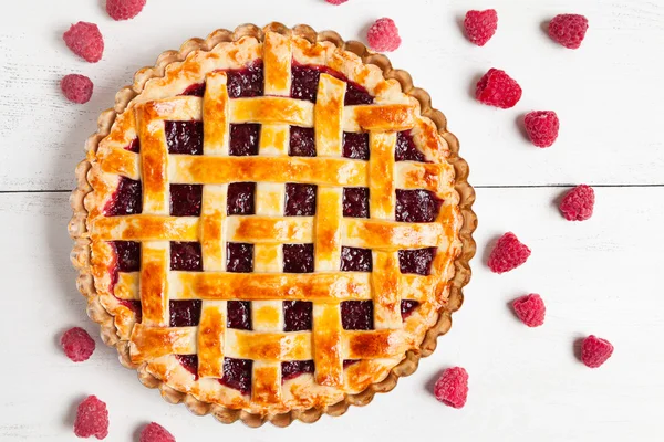 Homemade raw raspberry pie greased with egg yolk and jam on white kithen table — Stock Photo, Image