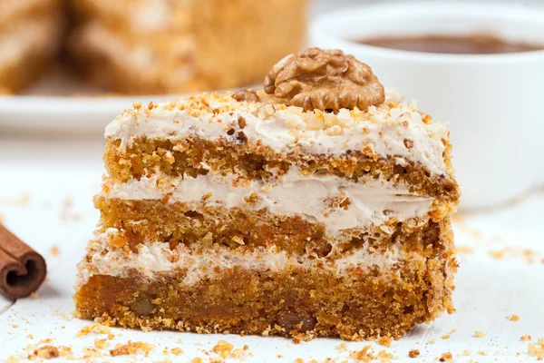 Piece of delicious treat carrot cake sweet dessert with pastry cream, walnut, cinnamon and coffee — Stock Photo, Image