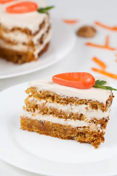 Нарізаний морквяний торт з вершками на білій тарілці — стокове фото