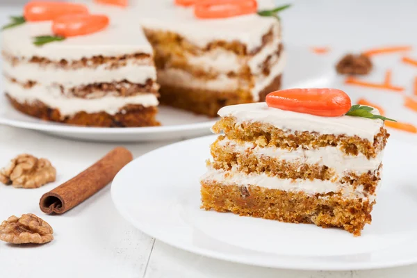 Deliciosa fatia de bolo de esponja de cenoura com creme de confeiteiro e pequenas cenouras laranja — Fotografia de Stock