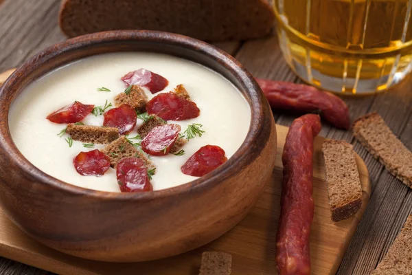 Bowl of white cream beer soup with sausage and croutons on woode — Stock Image Bowl of white cream beer soup with sausage and croutons on woode Royalty Free Stock Photos