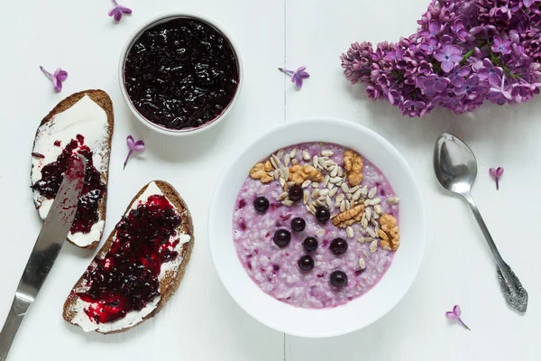 Healthy breakfast. Oatmeal porridge muesli with nuts, sunflower seeds, berries and berry jam. — Stock Photo, Image