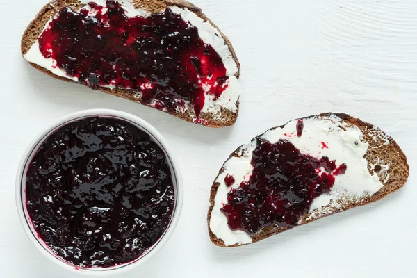 Heathy whole wheat toast with butter and jam on white kitchen table — Stock Photo, Image