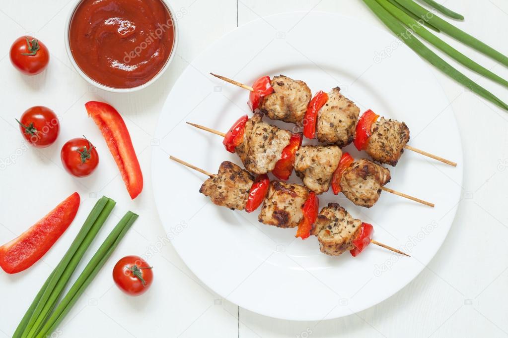 Traditional turkey kebab skewer barbecue meat with vegetables and sauce on white dish