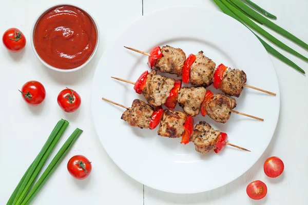 Traditionelle gebratene Putenspieße vom Grill mit Gemüse und Soße auf weißem Teller. serviert Küchentisch Hintergrund. — Stockfoto