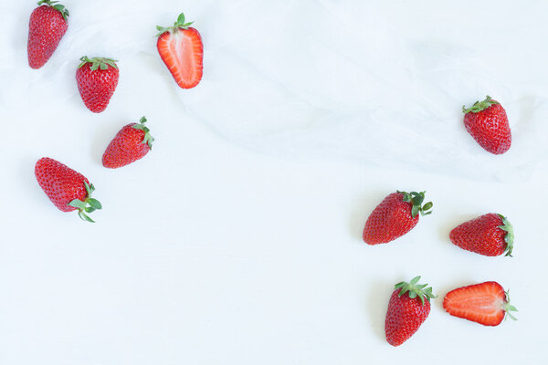 Fresh summer strawberries vegetarian clean eating super vitamin food with empty frame for lorem ipsum design text on white kitchen table background