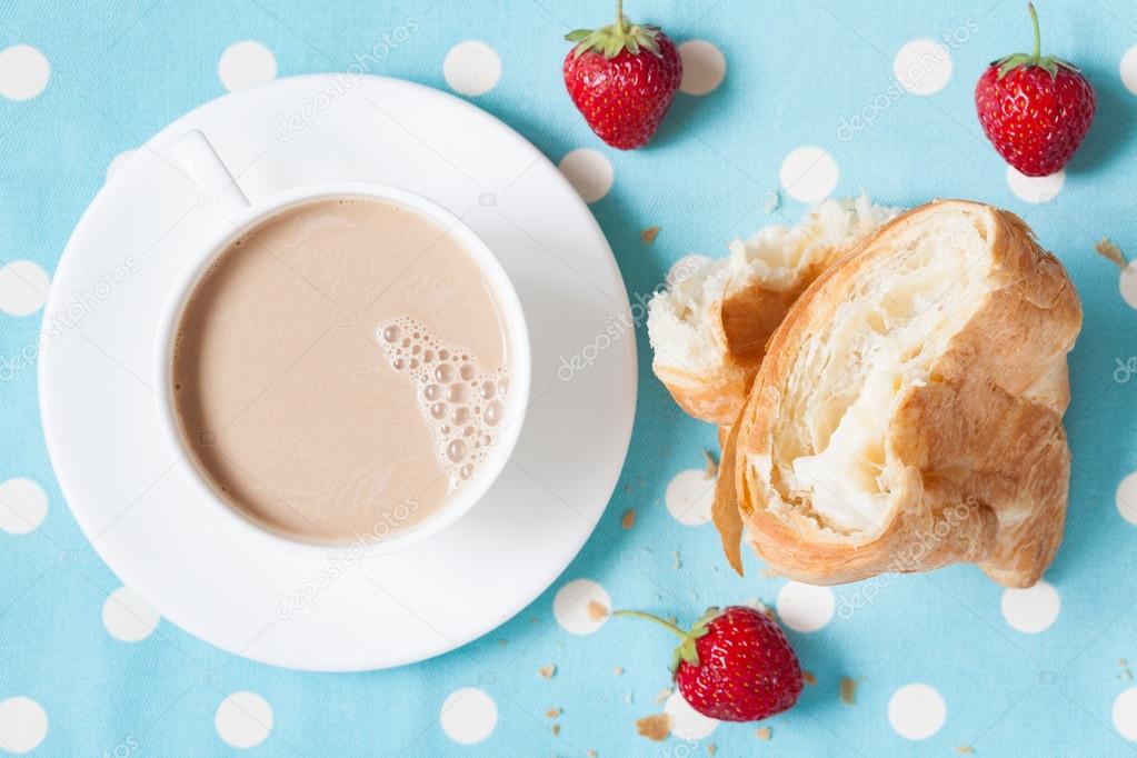 Concept perfect lunch or breakfast. A cup coffee latte with a piece of traditional French croissant pasrty and fresh strawberries on provence style background