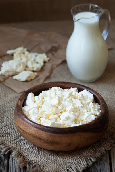 Домашний традиционный творожный молочный продукт с молоком в деревенском деревянном блюде на винтажном кухонном столе — стоковое фото