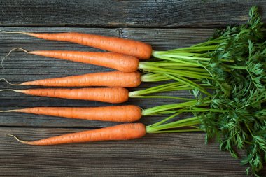 Bunch of carrots rustic harvest healhy organic vegetarian food on vintage wooden background