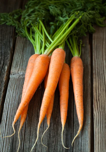 Bunch of carrots healthy vegetarian raw snack on vintage wooden background