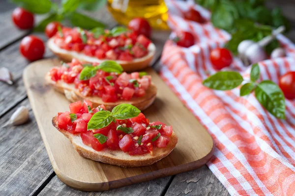 Traditional italian bruschetta vegetarian bread snack antipasti. Roasted sandwich with tomatoes, garlic and basil. — стокове фото