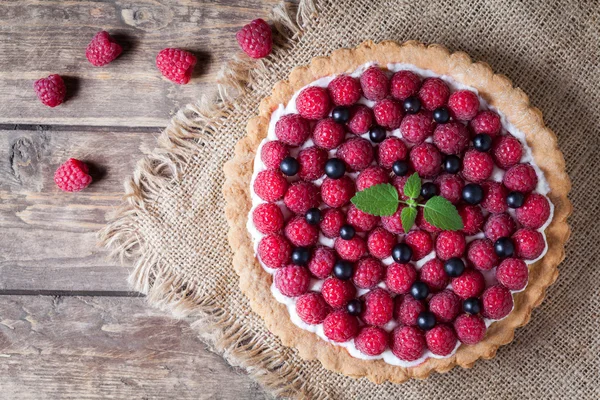 Gourmet homemade raspberry tart pie. Traditional cake with raspberries, blackberry and whipped cream on vintage wooden background — Stock Photo, Image