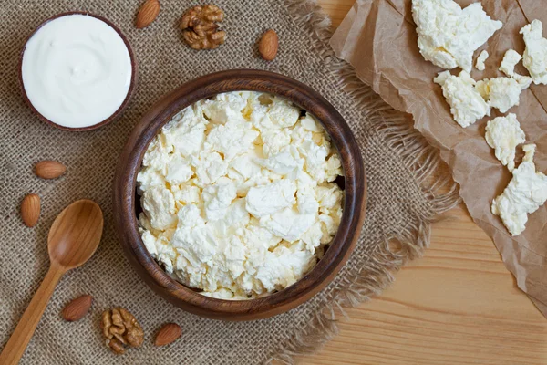 Homemade cottage cheese healthy dairy product with nuts in rustic wooden dish on vintage kitchen table background — Stock Photo, Image