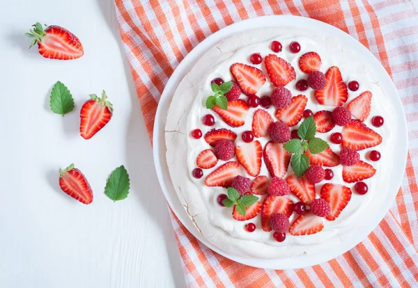 Traditional homemade Australian meringue dessert cake with whipped cream and strawberry on plate. White vintage table background. — Stock Photo, Image