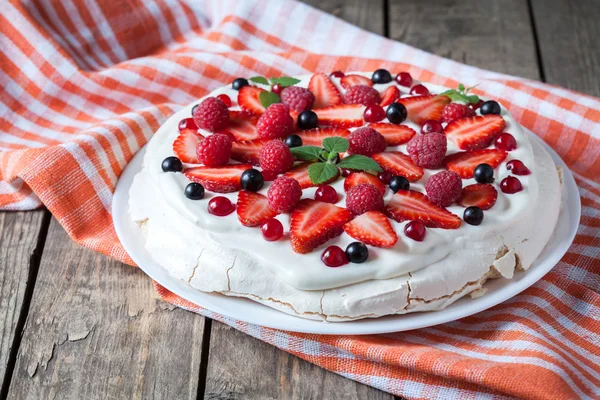 Organic de casă desert tradițional bezea dulce tort cu frișcă, căpșuni, mure și mentă pe placă albă. Tabel de fundal din lemn vintage . — Fotografie, imagine de stoc