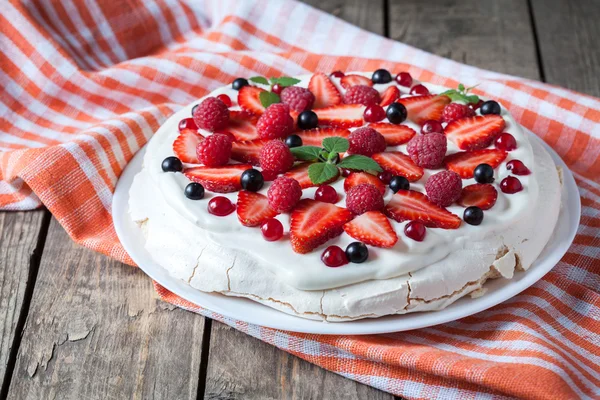 Pastel dulce de merengue tradicional casero ecológico con crema batidora, fresa, mora y menta en plato blanco. Mesa de fondo de madera vintage . — Foto de Stock