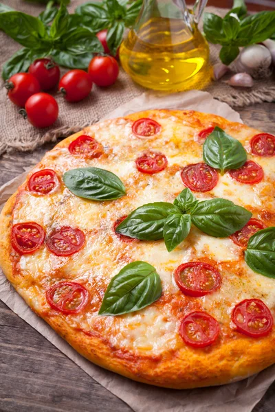 Italiensk traditionell pizza margherita. Hemgjord bakat läcker måltid med basilika tomater och mozzarella på vintage träbord bakgrund — Stockfoto