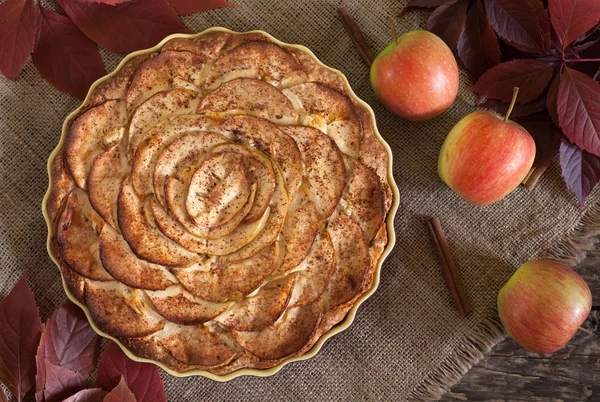 Traditional holiday celebration homemade apple pie sweet dessert food with cinnamon and apples on vintage wooden background. Top view. Autumn decor. — Stock Fotó