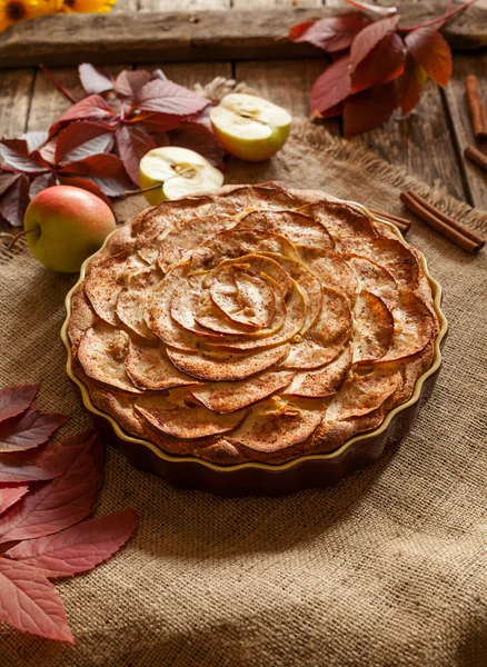 Homemade sweet traditional apple pastry cake for holiday celebration with cinnamon and apples on vintage wooden background. Autumn decor. — Stock Fotó