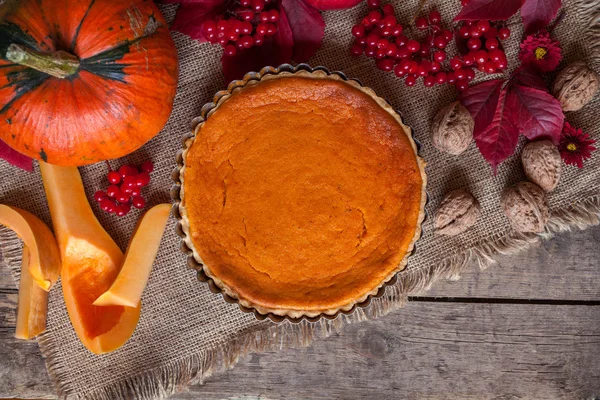 Traditional delicious pumpkin tart pie dessert food  with nuts and fall composition on vintage wooden background. — Zdjęcie stockowe