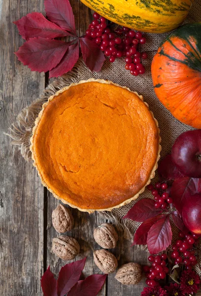 Traditional pumpkin pie halloween sweet treat tart with nuts and fall composition on vintage wooden background. — Zdjęcie stockowe