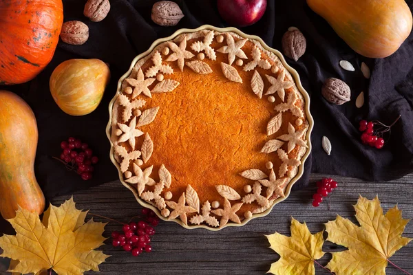 Homemade pumpkin tart pie organic sweet dessert food with various decoration on top. Traditional halloween or thanksgiving day healthy treat. Autumn composition,  vintage wooden background — Zdjęcie stockowe