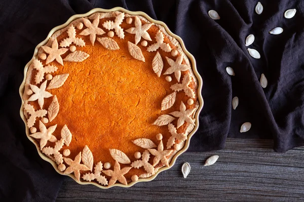 Delicious traditional thanksgiving pumpkin tart pie sweet organic dessert recipe with various decoration on top. Healthy nutrition vegan pastry.  Dark cloth, vintage wooden table background. — Zdjęcie stockowe