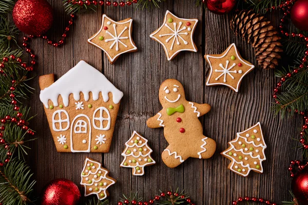 Gingerbread man home fur tree and stars cookies composition with christmas decorations on vintage wooden table background. Homemade traditional recipe. — Stock Fotó