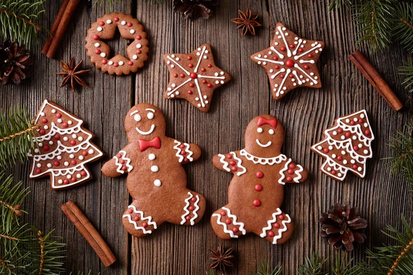Gingerbread man and woman couple, fur trees, star, christmas cookies composition with xmas tree decoration on vintage wooden table background. Homemade tradition dessert food recipe. — Stock Photo, Image