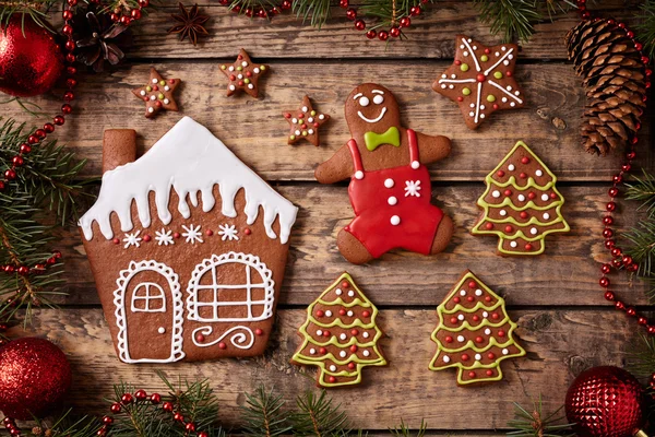 Christmas gingerbread cookies composition, man, stars, house and fur tree in xmas decorations frame on vintage wooden table background. Top view. Homemade traditional dessert food preparation recipe. — Zdjęcie stockowe