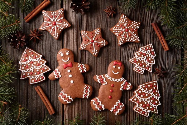 Gingerbread man and woman couple, fur trees, star, christmas cookies composition with xmas tree decoration on vintage wooden table background. Homemade tradition new year dessert food recipe. — Zdjęcie stockowe