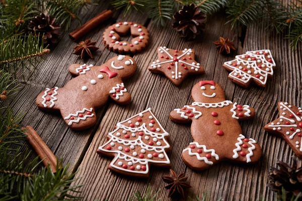 Gingerbread cookies man and woman couple christmas composition with icing on vintage wooden table background. Traditional homemade recipe. — Zdjęcie stockowe