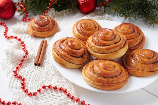 Cinnamon bun rolls homemade christmas sweet dessert on white vintage table with new year decorations. Traditional swedish kanelbullar baked pastry. — Stock Photo, Image