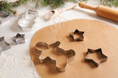 Gingerbread cookies dough with spices preparation recipe, cinnamon rolling pin and flour on white kitchen table. Traditional homemade christmas dessert.