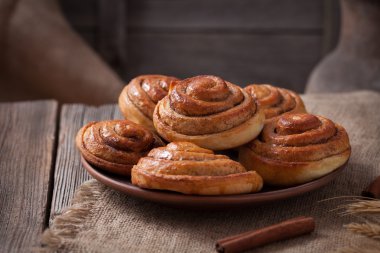 Rulo tarçın topuz Noel ev yapımı lezzetli tatlı tatlı tatlı vintage woonde masada buzlu. Pasta pişmiş geleneksel İsveç kanelbullar.