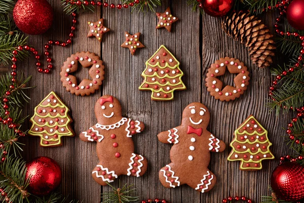 Gingerbread man and woman, fir trees, stars, christmas cookies composition with xmas tree decoration on vintage wooden table background. Homemade traditional new year dessert food recipe. — Stock Photo, Image