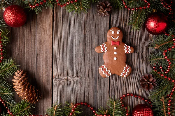 Christmas gingerbread man cookie composition in fir tree decorations frame on vintage wooden table background. Traditional homemade dessert recipe. — Stock Photo, Image