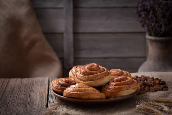 Rollos de bollo de canela dulce Navidad delicioso postre dulce sobre fondo de mesa vintage. Receta tradicional de pastelería al horno kanelbullar sueco . — Foto de Stock