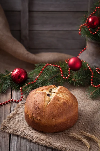 Pastel italiano tradicional de Navidad panettone casero con pasas y decoraciones de año nuevo postre de vacaciones en estilo rústico sobre fondo de mesa de madera vintage — Foto de Stock