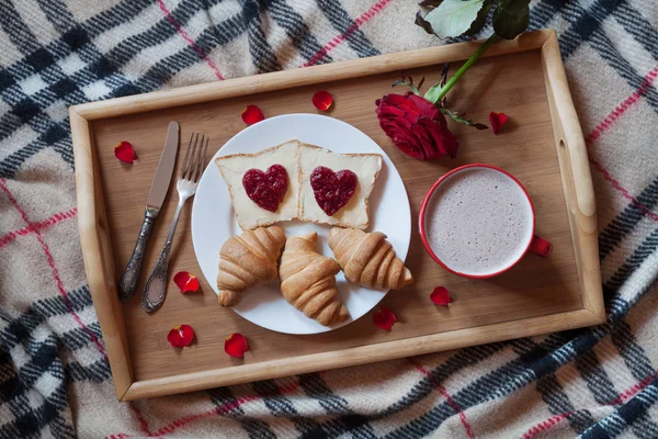 Breakfast in bed romantic surprise, toasts with jam, croissants and hot chocolate on tray. — Stockfoto