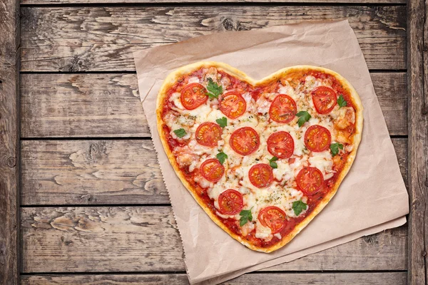 Pizza margherita a forma di cuore con pomodoro e mozzarella per San Valentino su fondo vintage in legno. Cibo concetto di amore romantico . — Foto Stock