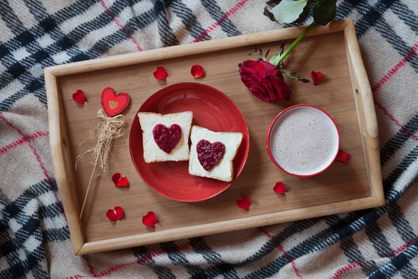 Delicious breakfast in bed on valentines day celebration holiday romantic present with rose flower, toasts and hot chocolate