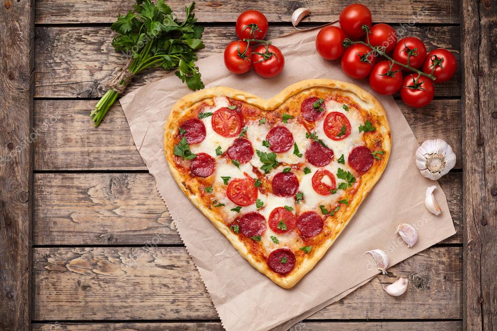 Pizza heart shaped with pepperoni, tomatoes, mozzarella, garlic and