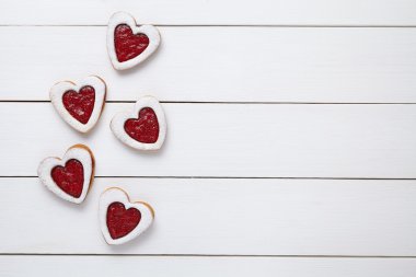 Heart shaped cookies with jam for Valentines day on white wooden background