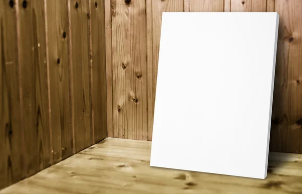 Poster bianco bianco bianco appoggiato alla parete di legno — Foto Stock